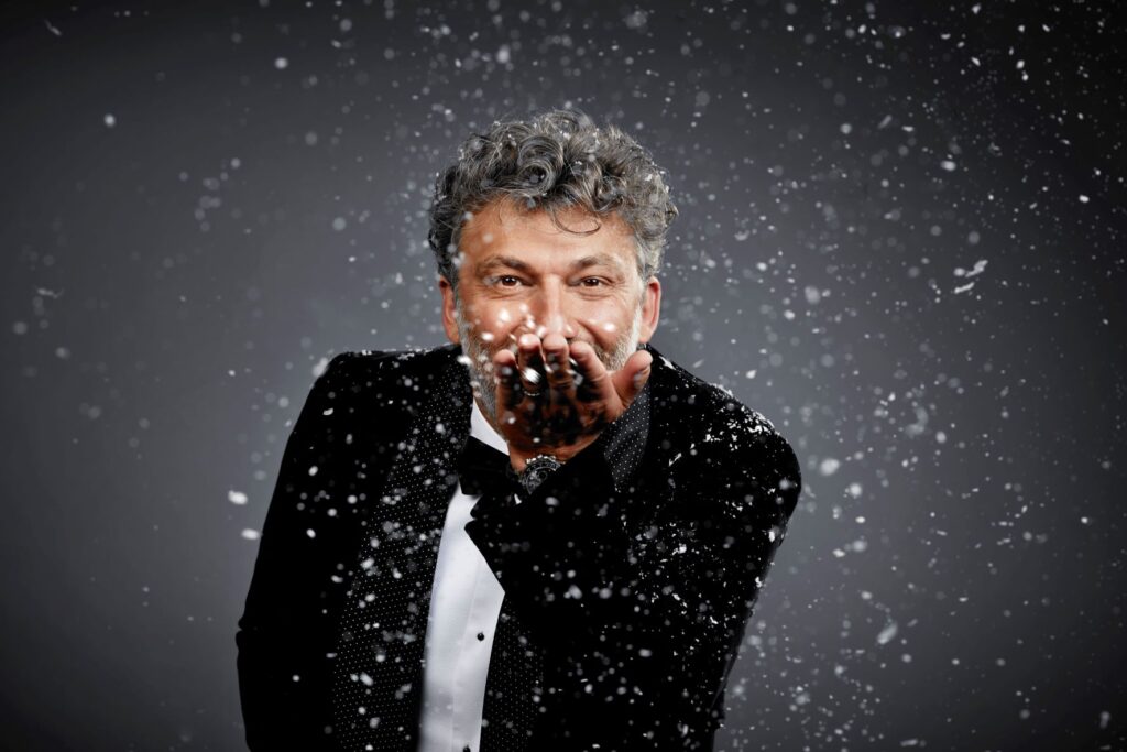 Jonas Kaufmann im Smoking pustet Schneeflocken in die Kamera
